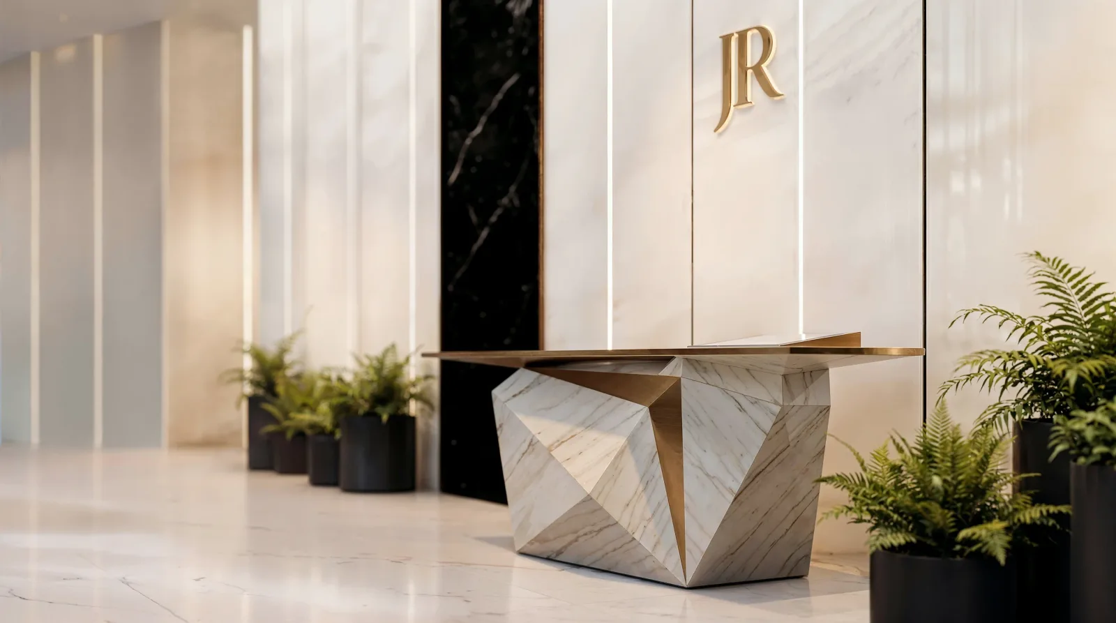 A faceted marble desk with a bronze top against a lit stone wall, ferns in black planters beside it